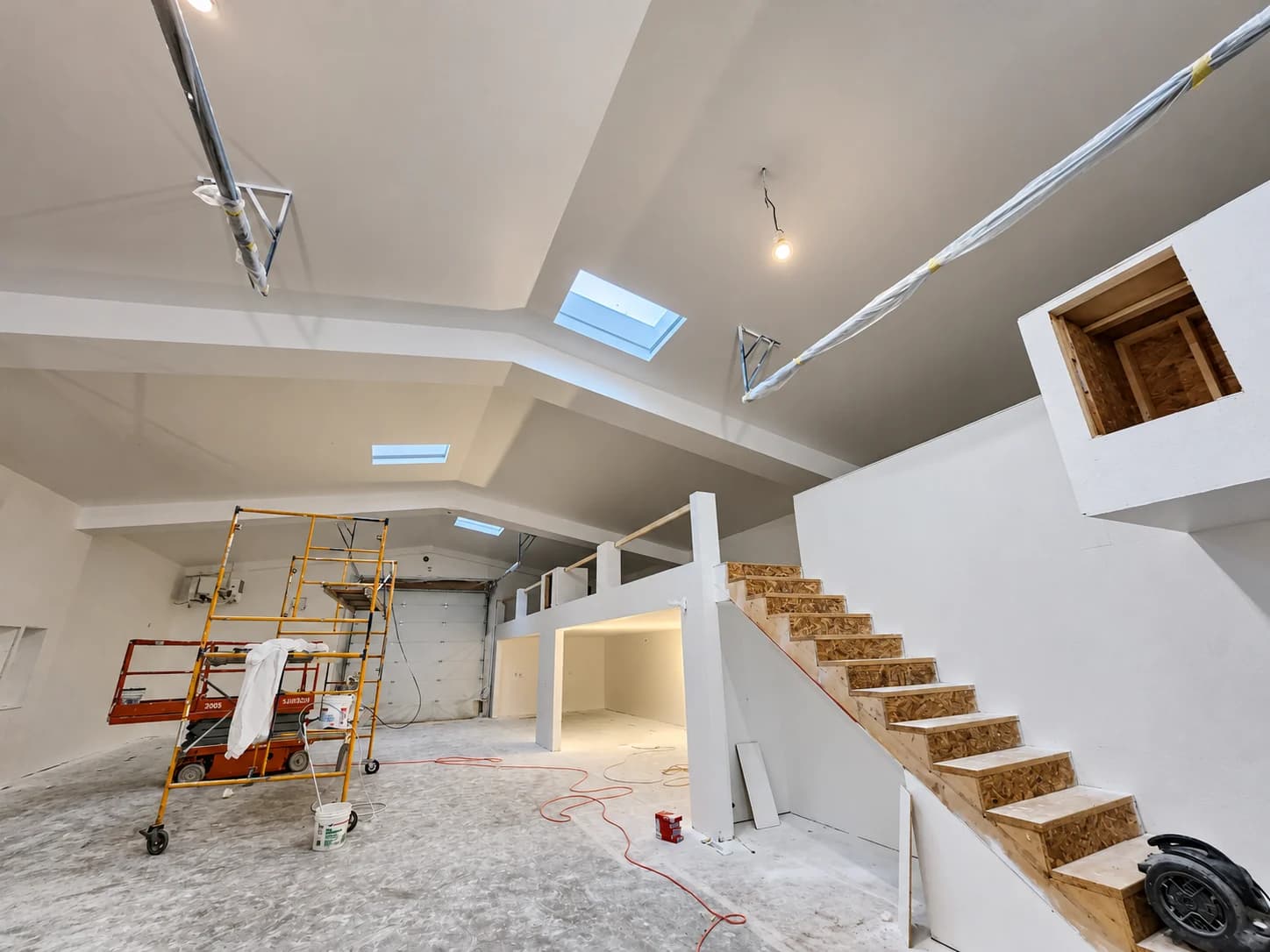 Drywall walls and skylit ceiling around an open staircase